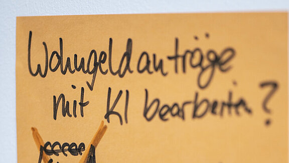 Post'it Wohngeldanträge mit KI oranger Post'it mit dem Inhalt: Wohngeldanträge mit KI bearbeiten?