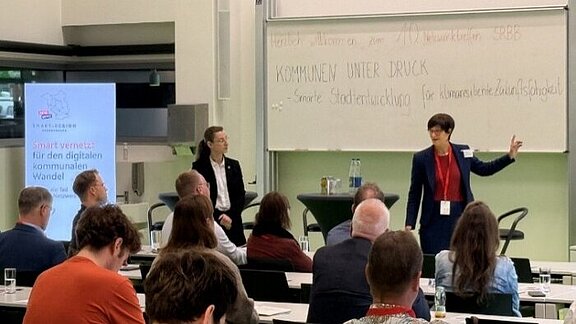 Gisela Fabian und Dr. Inga Bergmann-Wolf vor Plenum Gisela Fabian (MIK) und Dr. Inga Bergmann-Wolf (LGB)stellten den geplanten Digitalen Geobasiszwilling Brandenburg vor.