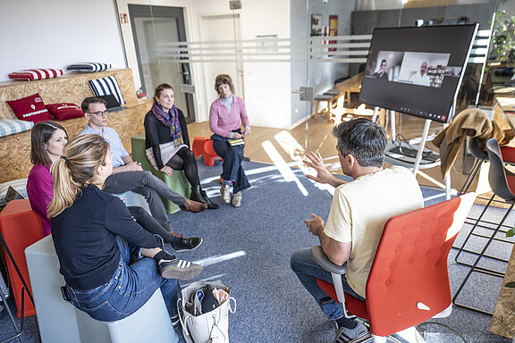 Gruppe von Menschen sitzt im Kreis und diskutiert