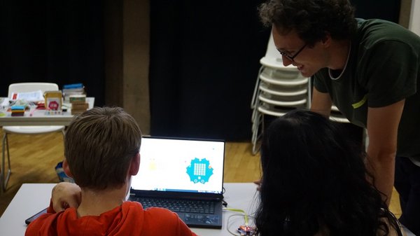 Zwei Jugendliche am Laptop mit Workshopleiter