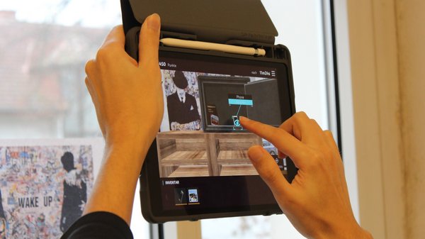 AR-Anwendung (Escape-Room) auf Tablet (Nahaufnahme mit Hand) 